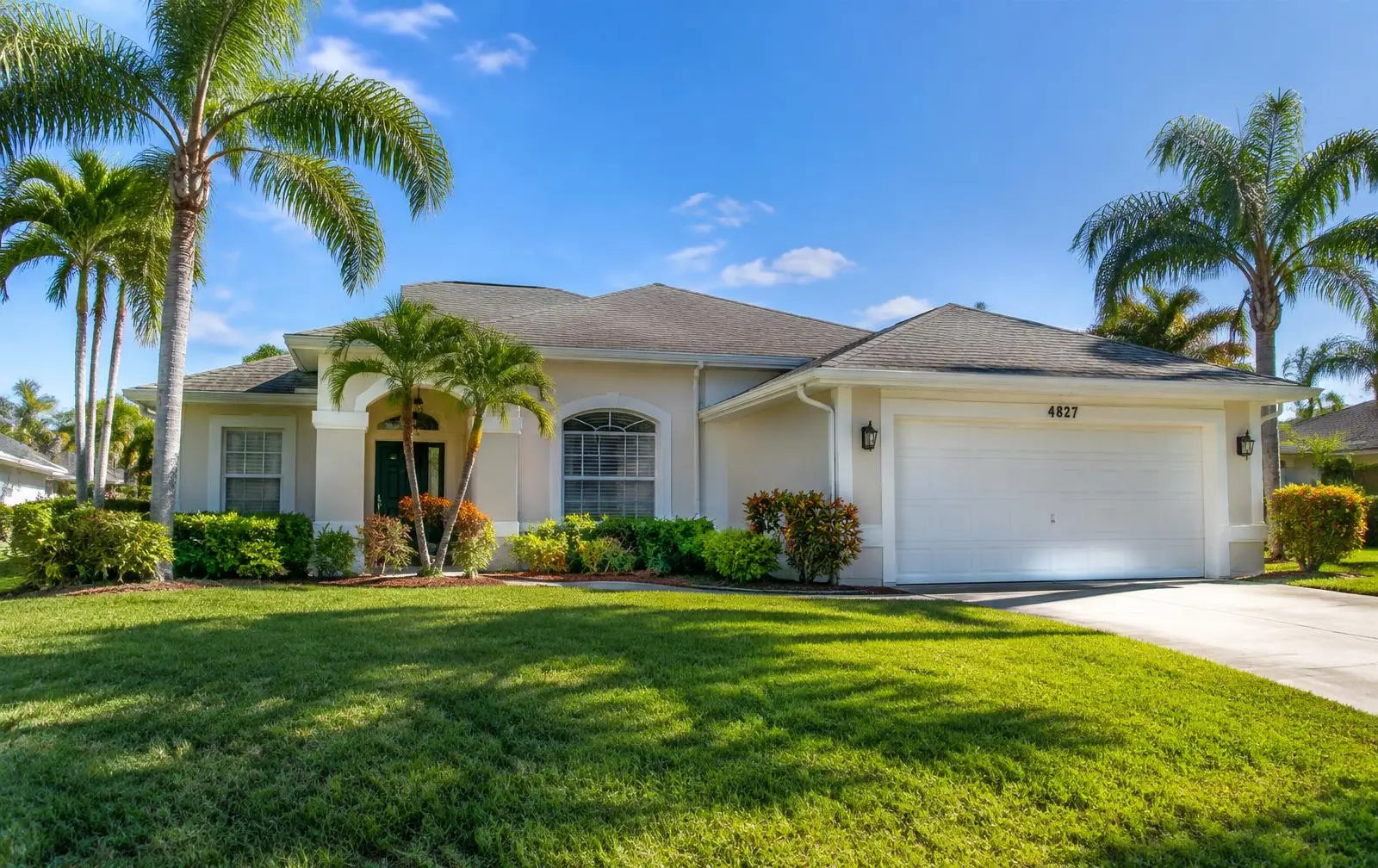 A shingle-roofed Tampa Bay home with palm trees